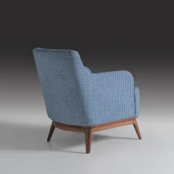 Poltrona imbottita di colore azzurro con piedi in noce canaletto*Annibale Colombo New