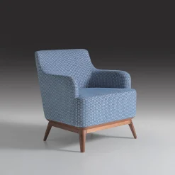 Poltrona imbottita di colore azzurro con piedi in noce canaletto*Annibale Colombo New